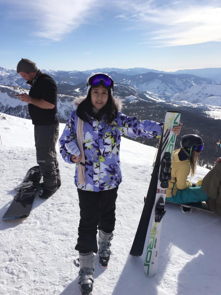 Girl in ski suit in a snowy mountain